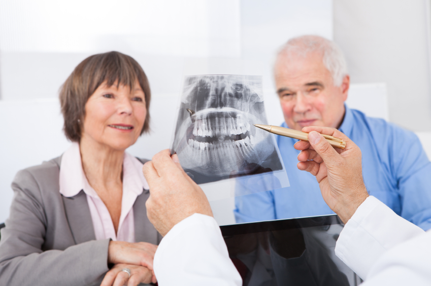Dentist Explaining X-Ray To Senior Couple Zahnarztangst - Röngtenbild Gebiss